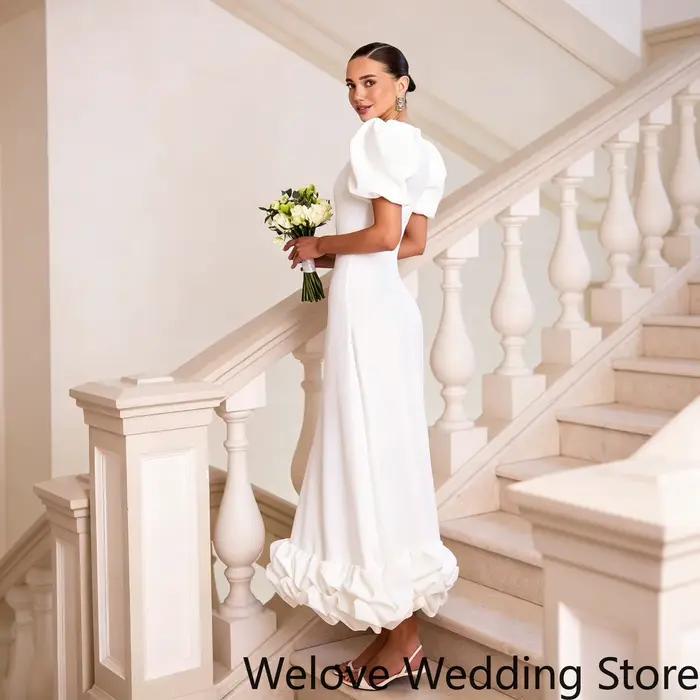 Robe de mariée blanche élégante et moderne, avec des manches bouffantes volumineuses, un corsage aju