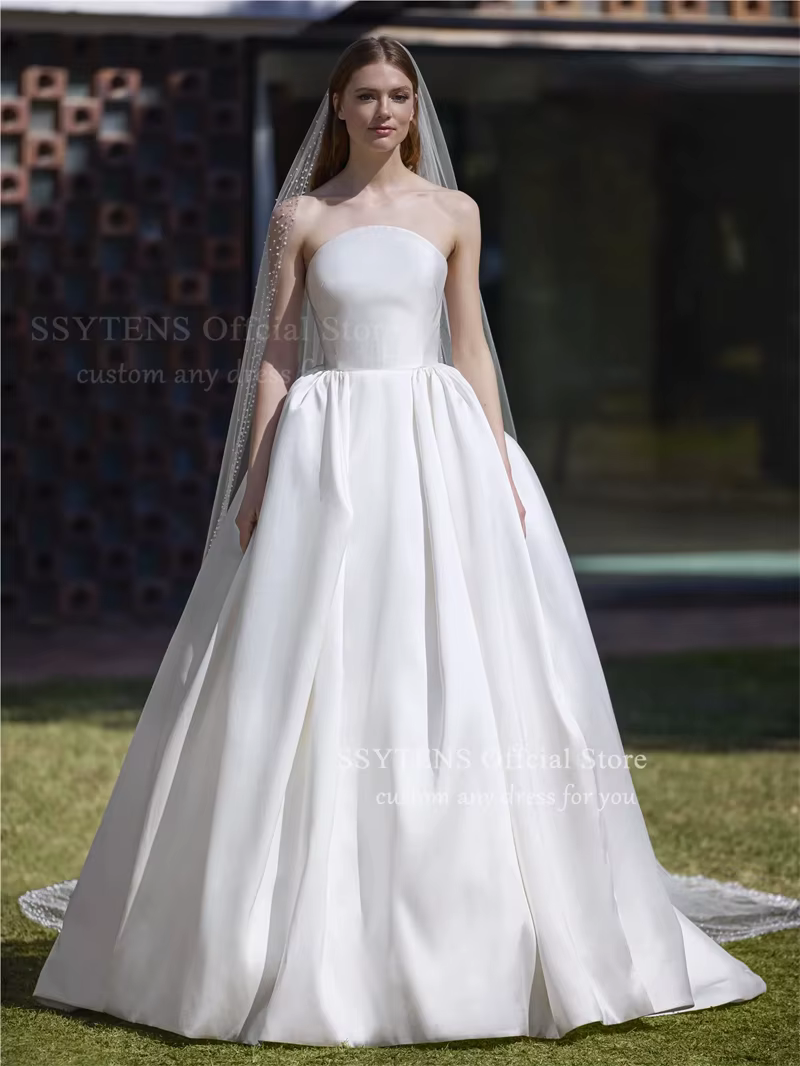 Robe de mariée élégante sans bretelles en satin, style princesse, avec boutons au dos, traîne courte