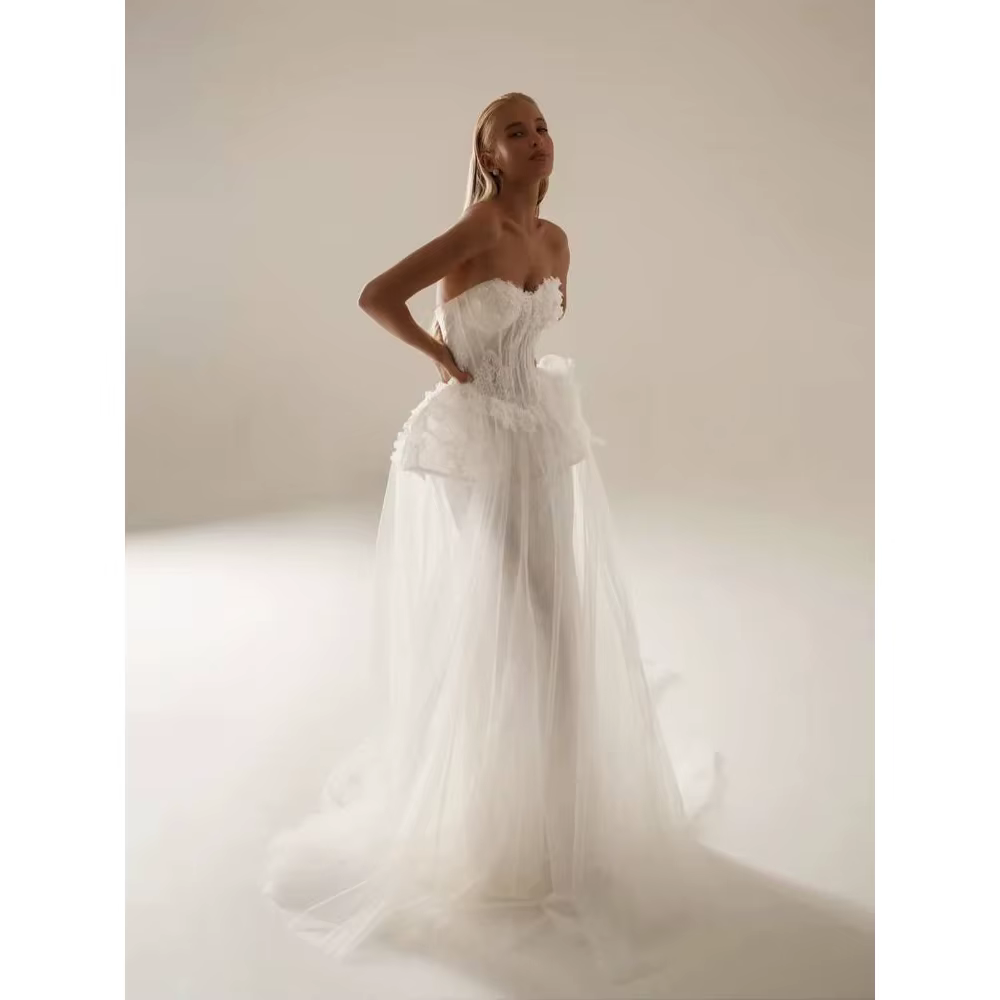 Robe de mariée en tulle superposé ivoire avec corsage bustier, taille à volants et péplum, robe de m