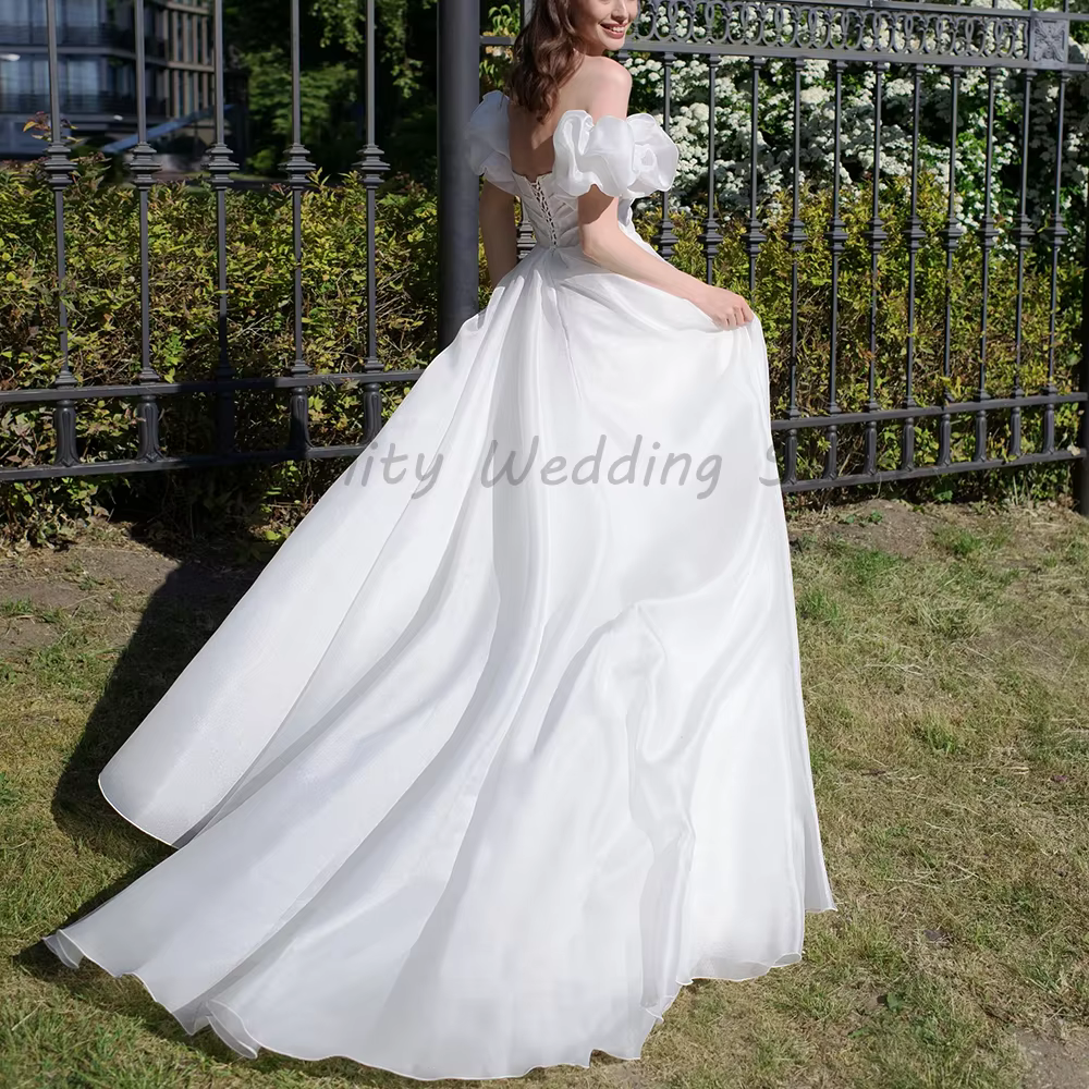 Robe de mariée blanche à épaules dénudées avec manches bouffantes et décolleté cœur perlé