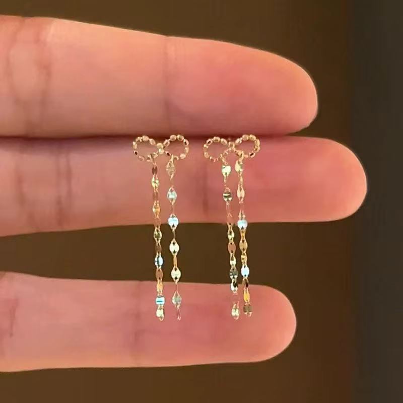 Boucles d'oreilles à pompons dorés 2026 – Design minimaliste