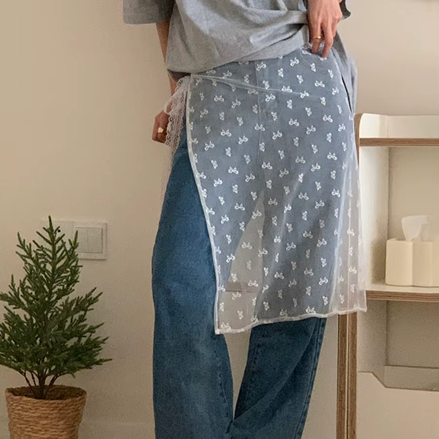 La robe en dentelle avec une couverture de rideau crée un look superposé par un tablier
